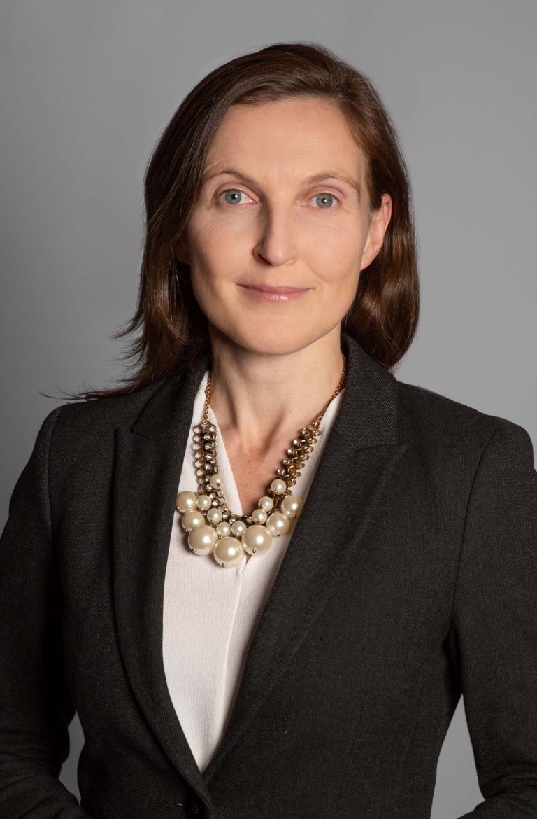 Gerlinde Groitl Porträtfoto 3 Gerlinde Groitl in Blazer mit Perlenkette, posiert vor neutralem Hintergrund.