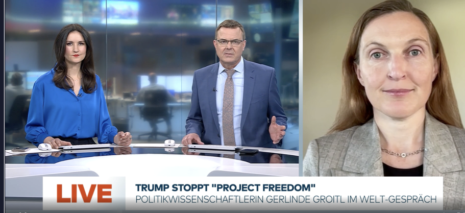 BR24 Interview Nachrichtenszene im Fernsehstudio mit US-Präsident Trump und Bundeskanzler Merz im Hintergrund.