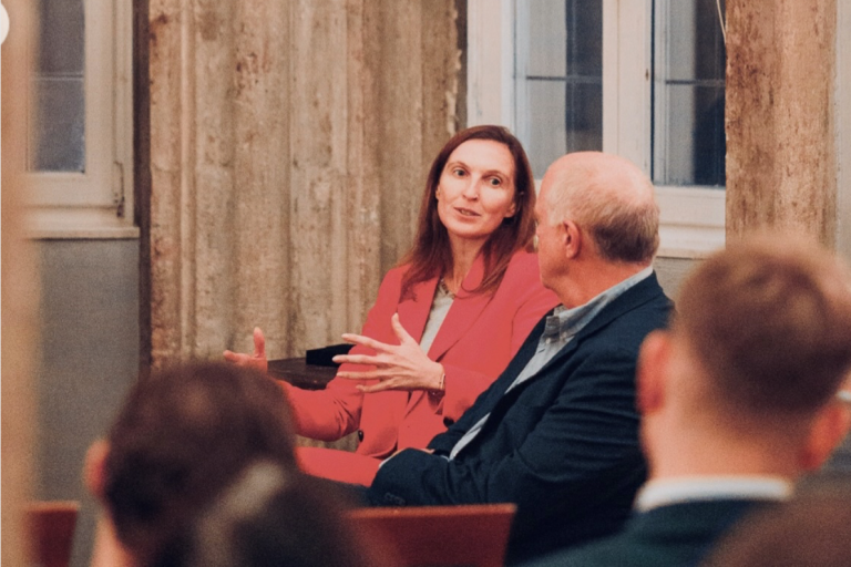 Podiumsdiskussion Prinz-Carl-Palais Mai 2025 Fünf Personen stehen vor einem Wand mit Flaggen und einer offiziellen Gestaltung.