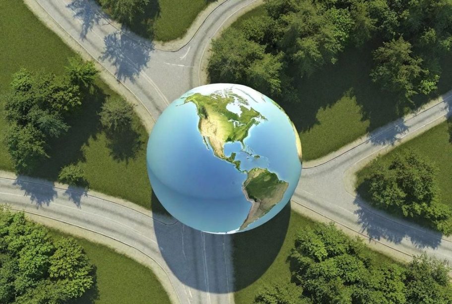 Symbolbild Radiodiskussion Weltlage Eine globe Erdkarte liegt auf einer Kreuzung von Straßen, umgeben von Bäumen.