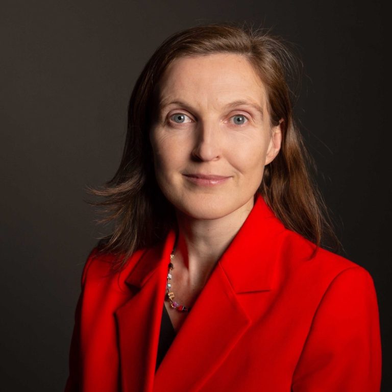 Gerlinde Groitl Porträtfoto 2 Gerlinde Groitl, die einen roten Blazer trägt, neutraler Hintergrund.