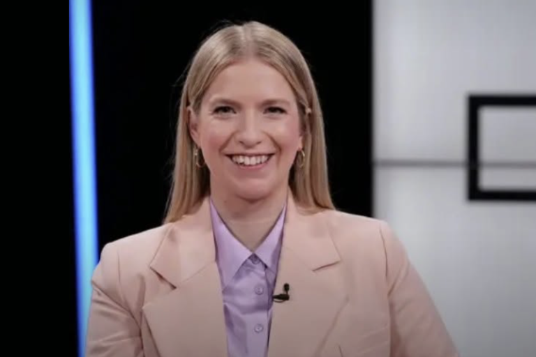 Frau in rosa Blazer in einem Fernsehstudio