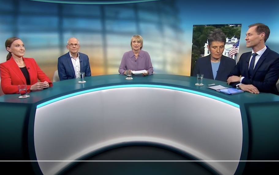 BR24 Interview Nachrichtenszene im Fernsehstudio mit US-Präsident Trump und Bundeskanzler Merz im Hintergrund.